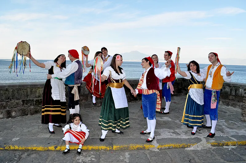 The costumed group on the seafront, with a little girl sitting in the foreground