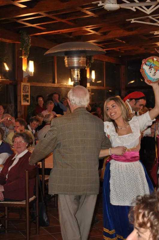 A dancer dances the tarantella with a guest during a dinner show