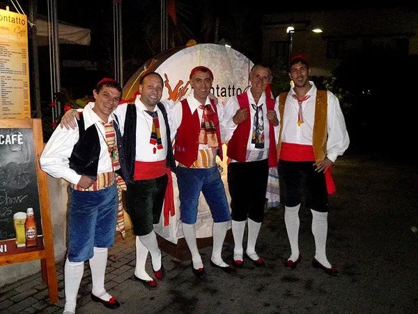 Five male dancers in costume posing in the street on a summer evening