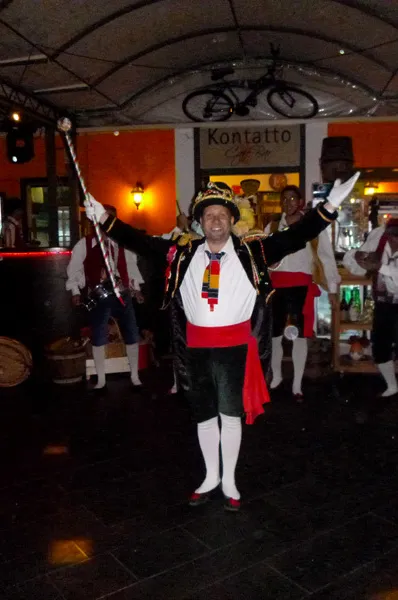 The tarantella leader with staff and hat leads the group during an evening at a venue