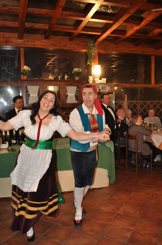 A couple dancing the tarantella sorrentina among the tables of a restaurant veranda