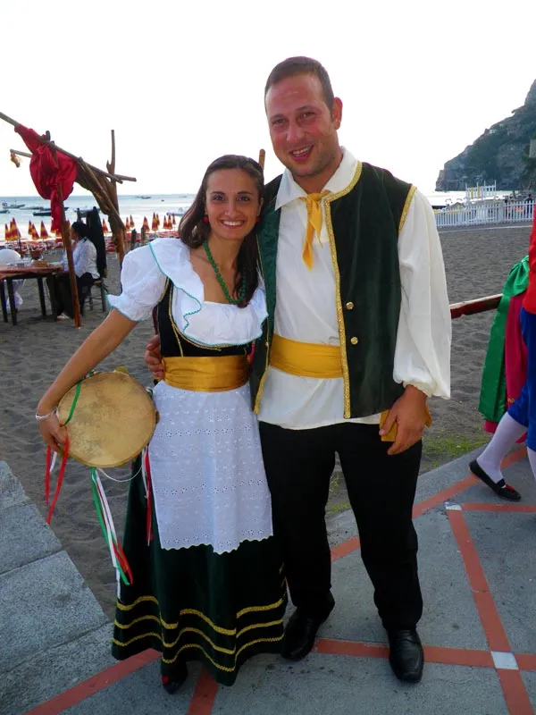 A couple in costume posing on a beach club at sunset before the show