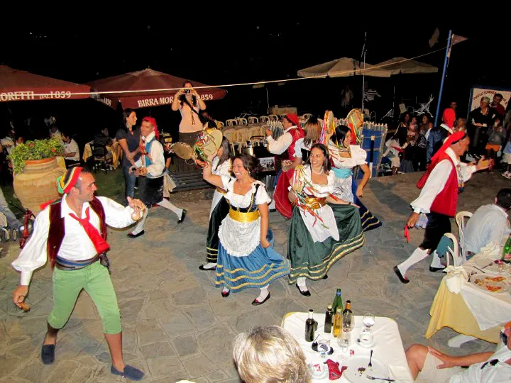 Ballerini di tarantella tra i tavoli di una cena