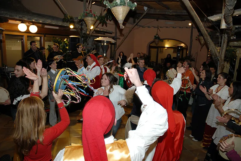 The dancers draw in the audience, shaking tambourines during a party at a restaurant