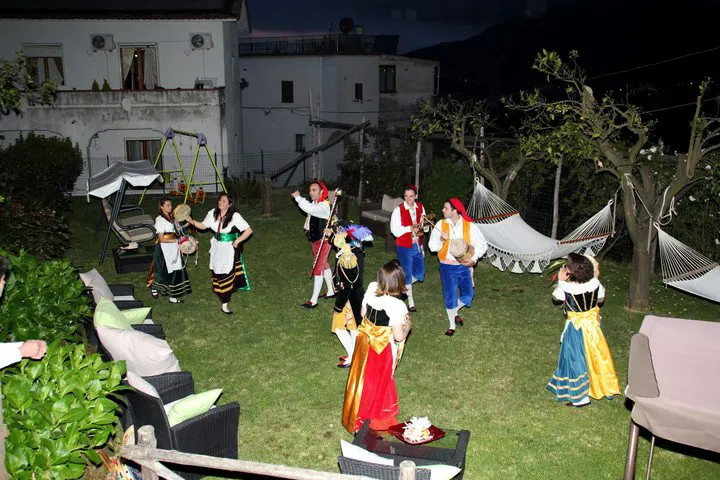 A tarantella sorrentina show in the lit garden of a villa at night