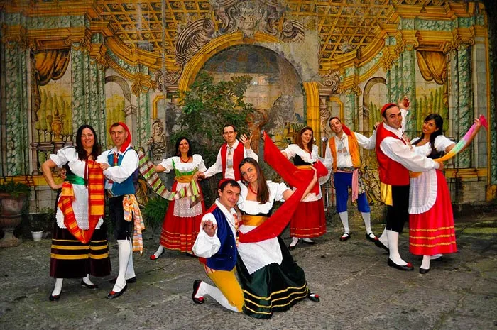 A tarantella sorrentina figure with the men kneeling before their partners in a frescoed courtyard