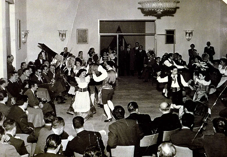 Vintage photo: couples dancing the tarantella sorrentina in a hall packed with spectators