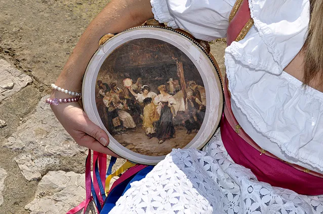 Painted tamburello held in the hand